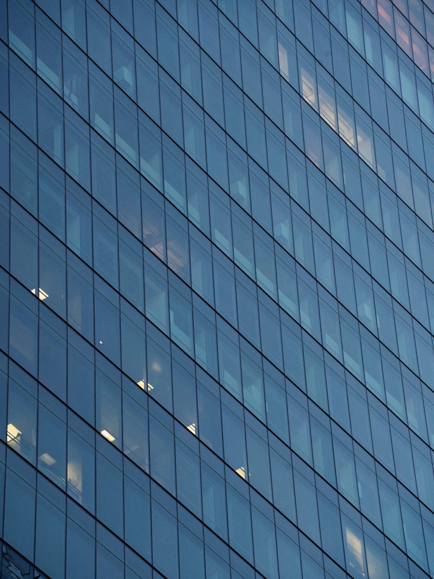Modern glass office tower at dusk