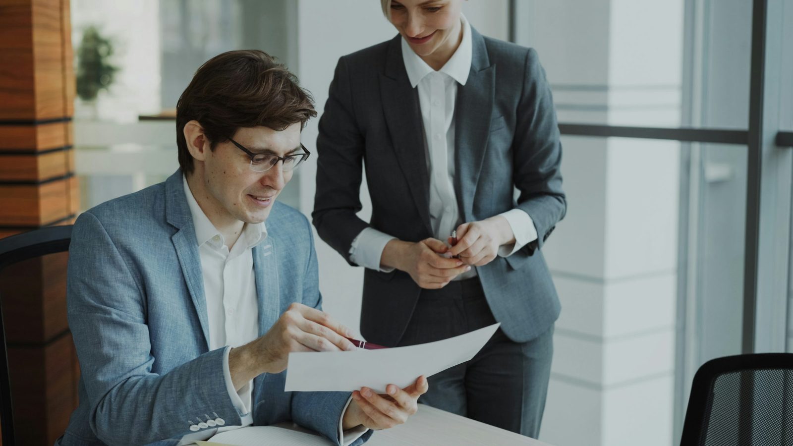 Two consultants reviewing a client's financial documents together